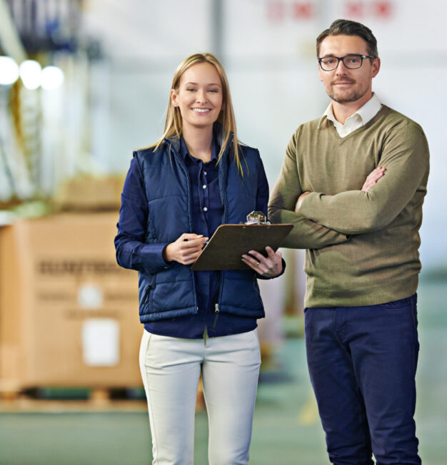 Warehouse, portrait and people with clipboard for distribution, inventory and boxes for shipping. Colleagues, team and collaboration on import or export, factory and papers for logistics on delivery.
